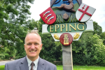 Dr Neil Hudson standing in front of Epping sign 