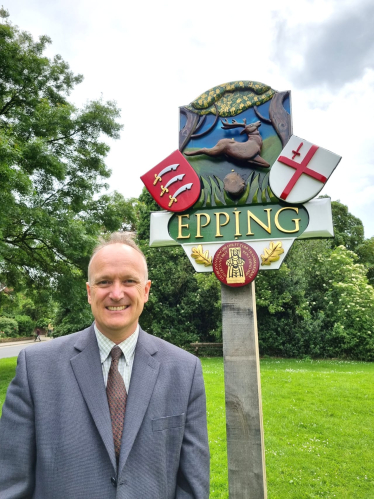 Dr Neil Hudson standing in front of Epping sign 
